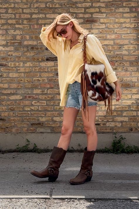 Summer outfit idea: frye harness boots, denim cut off shorts, vintage oversized button down and an oversized fringe bag. I love this easy outfit idea, it felt fun and coastal with a little bit western. The oversized sunnies are vintage from the 70's. This big shorts small pants outfit is the perfect summer festival outfit idea. • coastal cowgirl • festival outfit ideas • summer outfit ideas • frye harness boot outfit • cowhide purse • butter yellow shirt • butter yellow • pale yellow • Harness Boots Outfit, Cowgirl Festival Outfit, Cowgirl Festival, Festival Outfit Ideas, Big Shorts, Frye Harness Boots, Cowhide Purse, Summer Festival Outfit, Easy Outfit