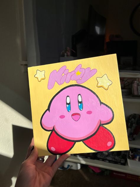 Square yellow canvas with centered Kirby painted pink with bright yellow stars above head. ‘Kirby’ reads along the top of the canvas in the font of the original game. Kirby Painting Canvas, Acrylic Painting Canvas Cartoon, Canvas Painting Ideas Characters, Character Canvas Painting, Kirby Acrylic Painting, Painting Ideas On Canvas Cartoon Characters, Kirby Drawings, Kirby Painting, Kirby Drawing