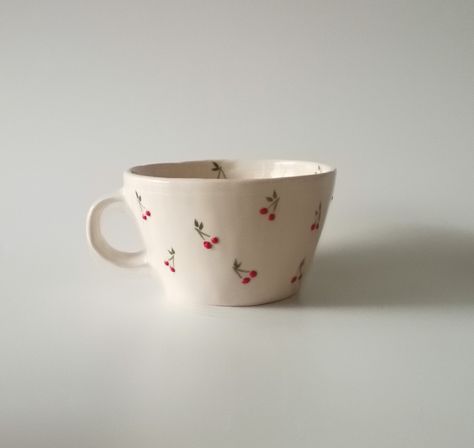 Introducing our exquisite handmade ceramic cup, a testament to craftsmanship and attention to detail. Each cup is meticulously shaped and adorned with a charming, hand-painted tiny cherry motif, adding a touch of whimsy to your daily rituals. Elevate your sipping experience with this unique piece that seamlessly combines functionality with artistic flair. Crafted with care, this cup is a delightful addition to any collection, promising both aesthetic pleasure and practical use. HandmadeCup, CeramicArt, CherryDesign, ArtisanPottery, WhimsicalCup, HandcraftedDrinkware, UniqueCeramics,CherryMotif, FunctionalArt, HomeDecor Kitchenware, ArtisticCup, CollectibleCeramics Cherry Mug Painting, Cute Kitchenware, Painting Cups, Hand Painted Coffee Mugs, Cute Bowls, Paint Cups, Ceramics Cup, Cup Painting, Crockery Design