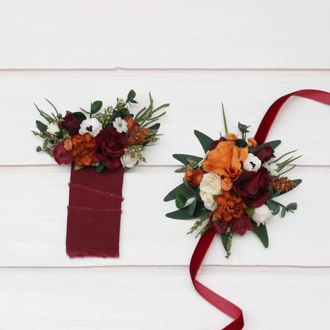 This stunning arrangement combines rich burgundy roses, delicate white flowers, and vibrant accents, all wrapped in an elegant burgundy ribbon. Perfect for the groom or groomsmen, this boutonniere adds a touch of sophistication and charm to any suit. #WeddingBoutonniere #WeddingAccessories #pocketboutonniere #GroomStyle #WeddingDecor #Boutonniere #BurgundyWedding#weddingboutonniere #weddindflorist #weddingvendor #weddindecor #corsage Burgundy Ribbon, Burgundy Roses, Rich Burgundy, Boutonniere Wedding, Burgundy Wedding, Groom Style, The Groom, Boutonniere, Wedding Vendors