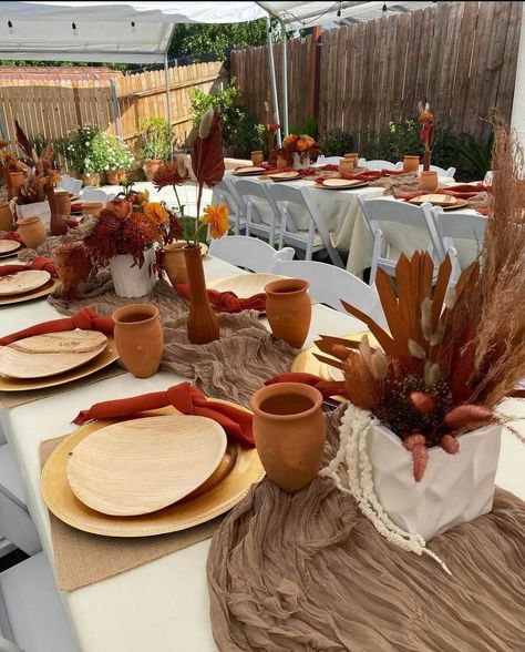 Host a festive Thanksgiving feast for your friends and arrange classy tablescapes. Drape an ivory tablecloth and lay down a natural gauze runner in the middle, next display classy floral centerpieces featuring a striking combination of autumn colors in white planter boxes. Assemble gold chargers with Birchwood plates and set stylishly knotted red napkins atop to give your Thanksgiving place settings a top notch feel. Arrange white folding chairs to give your guests a comfortable dining experienc White Planter Boxes, Pottery Party, Thanksgiving Dinner Decor, Fall Runner, Event Decor Ideas, Party Decorations Table, White Folding Chairs, Place Settings Thanksgiving, Red Napkins