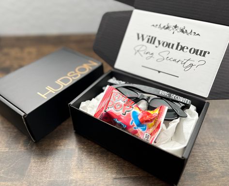 "Want to give the perfect Ring Bearer gift? Send this small Ring Bearer proposal gift box straight to your cute little cub. The box will arrive in a poly bag and then he will get to open a special box just for him.  --- LISTING DETAILS --- Includes 1 personalized small black box (6x4x2), personalized sunglasses, ring pop and will you be the ring security or ring bearer at our wedding note.  *Larger boxes available in my shop --- SUNGLASSES --- Listing comes with kids sized sunglasses (recommend ages 2-7) Frame size is approx. 5.12\"/ 13cm, glasses leg length is approx.5.12\"/ 13cm. Adult size recommended for 8 and up can be requested in the notes section. ---PRODUCTION & SHIPPING--- If you need this for an event, please enter the needed by date in the notes section at check out. RUSH MY OR Wedding Ring Bearer Proposal, Small Wedding Bridesmaids, Ring Bearer Box Proposal, Ask Ring Bearer Ideas, Ways To Ask Ring Bearer To Be In Wedding, Will You Be Our Ring Bearer, Ring Barrier Ideas Boys, Will You Be My Ring Bearer Ideas, How To Ask Ring Bearer To Be In Wedding