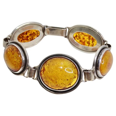 Introducing the 1970s Amber Silver Bracelet, a stunning vintage piece that combines vibrant color with elegant craftsmanship. This beautiful bracelet features five striking orange amber stones, each uniquely set in a handcrafted silver frame. The vibrant hue of the amber contrasts beautifully with the sleek silver setting, creating a whimsical and timeless accessory. The design of this bracelet exudes a vintage charm, with the natural inclusions in the amber adding character and uniqueness to ea Vintage Amber Jewelry, Adjustable Vintage Amber Jewelry, Luxury Vintage Amber Bracelets, Collectible Vintage Amber Jewelry, Hermes Necklace, 1970s Jewelry, Antique Amber-colored Sterling Silver Jewelry, Chanel Sandals, Amber Stone