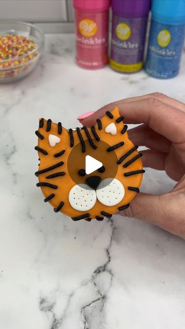 Rachel Lindsay on Instagram: "Easy tiger 🐯🧡🐯

The second animal in our ZOO 🦁🐯 
Which animal should we add next? 🥳🧡💛

I shaped my cupcakes using marbles. I added orange buttercream for the face and pressed it onto parchment paper. I popped him in the freezer for 15 minutes to allow the buttercream to firm. I then added sprinkles and black buttercream stripes.

#cupcake #cupcakedecorating #animalcupcakes #cakedbyrach #tutorial #tigercupcakes" Clemson Cupcakes, Animal Cupcake Ideas, Animal Cupcakes Easy, Tiger Cupcakes, Black Buttercream, Character Cupcakes, Orange Buttercream, Rachel Lindsay, Mermaid Cat