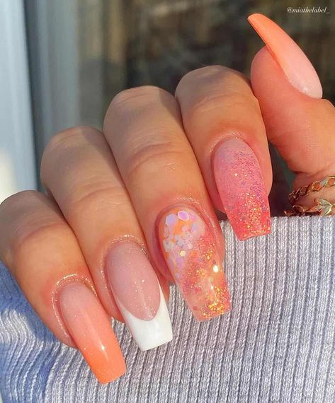 Looking for nail inspiration? You’ll love this list of coral peach nails. If you can’t decide between coral nails, or peach nails, the coral peach combo is a stunner! On this list you’ll find nails with designs, with glitter, with flowers, and simple French tip styles! There’s acrylic nails or natural short nails, as well as different shapes including almond, square, and coffin! This color is perfect for summer, fall, or on a tropical vacation! Peach Vacation Nails, Fall Coral Nails, Peach Sparkle Nails, Coral Summer Nails Designs, Tropical Vacation Nails Almond Shape, Peach Nails With Glitter, Peach Fuzz Nails, Coral Summer Nails, Peach Nails With Designs