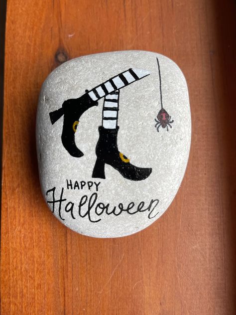 "Hand painted on a natural rock are witch's legs and a spider!  Sealed with gloss varnish to help preserve the art.   measures 4\" x 3 \" x 2\"." Witch Hat Rock Painting, Spooky Rock Painting, Witchy Painted Rocks, Halloween Painted Rocks Ghost, Halloween Stones, Halloween Witch Painted Rocks, Halloween Witch Legs, Fall Rocks, Painted Seashells