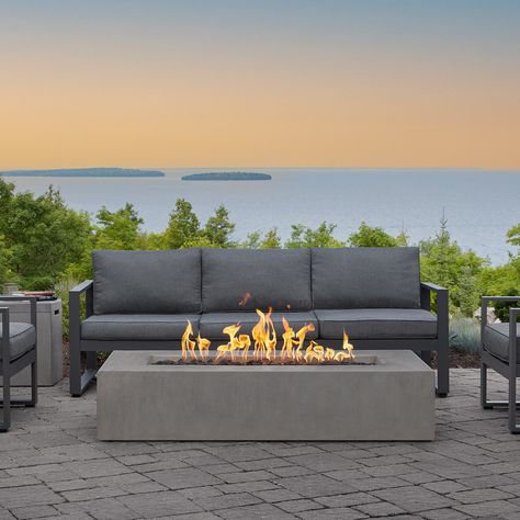 Create your ideal outdoor gathering space with the stylish and versatile design of this gas outdoor fire table. Made in the USA of glass fiber reinforced concrete (GFRC), the Estes Low Rectangle Fire Table has a simplified silhouette and a rustic finish, with a brass burner system that produces rich and inviting flames. Available in either natural gas or propane in a flint or carbon finish. Jensen Co. Amonte 60 in. NG Fire Table in Flint Polyester in Gray | 143NG-FLNT Propane Fire Table, Sofa Area Externa, Glass Fiber Reinforced Concrete, Outdoor Gathering Space, Outdoor Fire Table, Natural Gas Fire Pit, Rectangular Fire Pit, Propane Fire Pit Table, Gas Fire Table