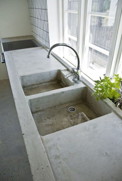 The kitchen area is characterized by a concrete countertop that was poured on site. The handmade triangular tiles above the stove were specially made by an artist from the Netherlands. Photo by Laura Stamer.  An Idyllic Swedish Summerhouse by Jaime Gillin Poured Concrete Counters, Concrete Kitchens, Outdoor Kitchen Sink, Concrete Countertop, Kabinet Dapur, Concrete Counter, Concrete Sink, Farmhouse Remodel, Concrete Kitchen