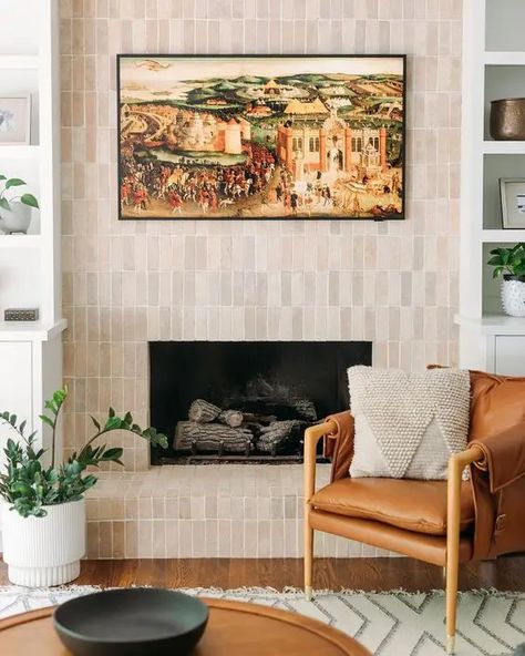 a fireplace clad with neutral skinny tiles is a stylish solution for a modern or mid century modern space Black Terracotta Tile Fireplace, Fireplace Zellige Tile, Tile Wall In Living Room, Natural Tile Fireplace, Modern Woodburner Fireplaces, Spanish Tile Fireplace Ideas, Zellige Fireplace Surround, Zellige Tile Fireplace Surround, Terracotta Fireplace Tile