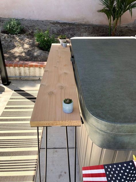 As we head into summer, make yourself an easy and affordable outdoor bar area! Whether its placed against your hot tub like ours, or just an extra space for food and drinks, it will add a custom look to your space!   Let's get started! Step 1:    Cut your wood to the length of your choosing. After your wood is cut to the length you need, use your electric sander to sand the wood until it is smooth to the touch. Step 2    Decide which side of your wood will be the top, and flip it over… Diy Outdoor Hot Tub, Hot Tub Bar, Outdoor Bar Area, Hot Tub Landscaping, Hot Tub Patio, Diy Outdoor Bar, Electric Sander, Hot Tub Deck, Balcony Bar