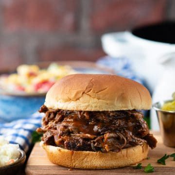 Tender, juicy, savory and sweet -- this Dutch Oven BBQ Beef transforms an affordable cut of meat into a delicious and satisfying lunch or dinner. Serve the shredded barbecue beef on sandwich buns with a side of coleslaw, corn salad, pickles or cucumber salad. It's an easy, family-friendly meal to enjoy all year long! Bbq Pulled Beef, Shredded Beef Sandwiches, Slow Cooker Bbq Beef, Sandwich Buns, Bbq Beef Sandwiches, Shredded Beef Recipes, Beef Barbecue, Best Freezer Meals, Pulled Beef