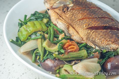 Boiled Vegetables with Fried Fish in Anchovy Sauce | 1 whole tilapia fried, 2 large plum tomato, 1 large yellow onion,  2 thumbs ginger,  12 pieces string beans, 3 to 4 pieces Indian eggplant,  6 to 8 pieces okra 1 cup jute leaves 1 medium bitter melon,  ¼ cup bagoong balayan or bagoong monamon (anchovy sauce) Dinengdeng Recipe, Steamed Fish Recipes, Anchovy Sauce, Fried Tilapia, Philippines Recipes, Filipino Dish, String Beans, Boiled Vegetables, Philippines Food