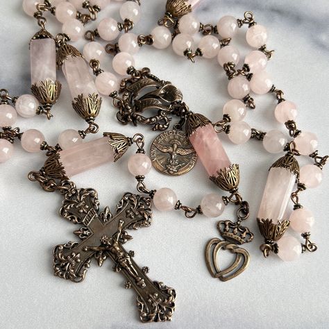 "THE IMMACULATE ROSE DIFFERENCE  CRAFTSMANSHIP | DESIGN | MATERIALS This magnificent rosary is made with larger parts and larger beads and is a longer and heavier rosary. It is made with soft pink Rose Quartz gemstone beads. It has a stunning Solid Bronze Grand Baroque crucifix with Fleur de Lis at each of the 4 points of the cross, It has a beautifully detailed Solid Bronze Calla Lily center, a Solid Bronze Sacred & Immaculate Twin Hearts medal and a Solid Bronze Holy Spirit Dove Medal.  The Sacred Heart has one of the deepest meanings in the Roman Catholic practice. The heart of Jesus is viewed as a symbol of God's boundless and passionate love for all mankind. The dove is symbol of truth and innocence. The sign of the dove was given to John the Baptist when he baptized Jesus. The two in Rose Quartz Rosary, Beautiful Rosaries, Holy Spirit Dove, Catholic Wallpaper, Intertwined Hearts, Decade Rosary, Wonderland Theme, Praying The Rosary, Christian Girl