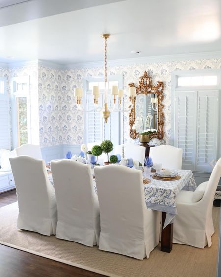 Dining room decor! White slip covered dining chairs, sisal rug, gold mirror. Blue and white grandmillennial chinoiserie wallpaper. Coastal Grandmother Dining Room, Grandmillenial Dining Room Decor, Grandmillennial Dining Room, Dining Room Decor White, Covered Dining Chairs, Slip Covered Dining Chairs, Room Decor White, Dining Room Inspo, Grandmillennial Style