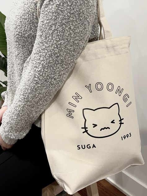 BTS Suga inspired Cat tote bag - Heavy Duty Recycled Cotton Canvas Tote Bags With Zipper and Inside Pocket - Bag measures 11.8" x 15.75" x 3.9" - Digital Design printed and heat transferred onto the fabric TOTE BAG CARE INSTRUCTIONS: -Do not machine wash -Hand spot clean ONLY Bts Tote Bag Design, Cute Tote Bag Design, Tote Bag Bts, Kpop Tote Bag, Run Everyday, Tote Bags With Zipper, Bts Bag, Bts Clothing, Fabric Tote Bag