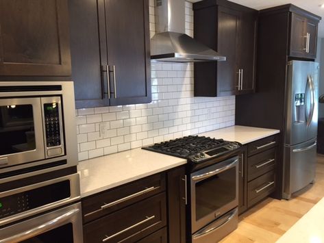 Dark shaker cabinets, white subway tile backsplash, quartz countertop and maple floors. Timeless combo. Subway Tile Kitchen Dark Cabinets, Kitchen Dark Cabinets, White Subway Tiles Kitchen Backsplash, White Subway Tile Kitchen, Backsplash With Dark Cabinets, Espresso Kitchen Cabinets, Kitchen Dark, Backsplash Kitchen Dark Cabinets, Espresso Cabinets