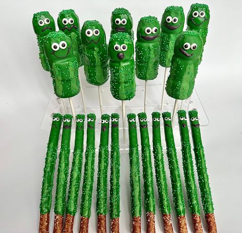 Fun and festive pickle party favors. This is a party package that includes the following treats: 12 Triple Marshmallow Pops 12 Chocolate Covered Pretzels  Each pretzel is coated in green colored chocolate and sprinkled with green nonpareils. Each triple marshmallow pop is rounded at the top and dipped in creamy green chocolate and then with more green nonpareils. Each treat is decorated with sugar eyes and chocolate mouths.  Each treat will be individually wrapped in a crystal clear cellophane sleeve and tied with green  ribbons.   Delightful Chocolates cannot be held responsible for melted or broken chocolate once the package has left our possession. We also cannot be held responsible for how the postal service treats or handles our packages. We take great pride in insulating our boxes an Pickle Party Theme, Pickle Birthday Party, Pickle Party, Colored Chocolate, Dipped Pretzel Rods, Green Snacks, Pickle Lover, Chocolate Covered Marshmallows, Covered Pretzels