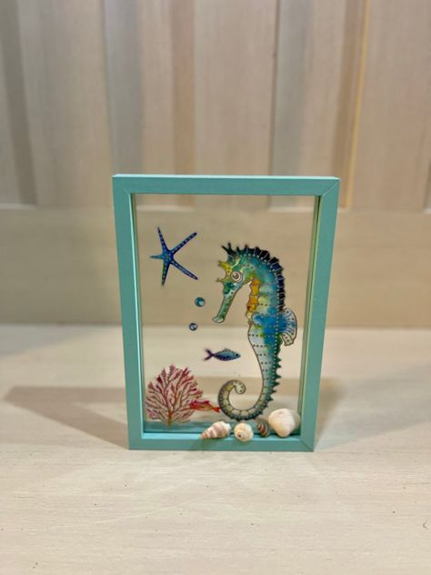 An easy seahorse glass sign DIY using a dollar tree frame and a beach glass sticker. Dollar Tree Seahorse, Dollar Tree Mermaid Decor, Beachy Picture Frames Diy, Sand Dollar Shadow Box Diy, Decoupage Sand Dollars, Fish Lanterns, Dollar Tree Frames, Burlap Art, Coral Wall Art