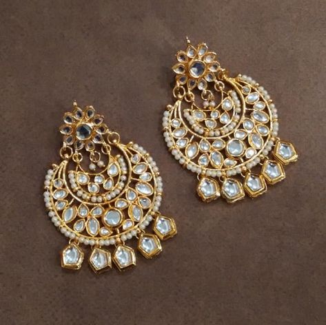 Choose from the elegant collection of chand bali earrings at Kalyan! Kundan chand bali earrings come in a large variety of styles and shapes. Buy original silver-toned and gold-toned kundan earrings, crescent-shaped earrings, mudra gold earrings and more from us. These earrings can go perfectly with both traditional and modern outfits. So please hurry up and check out the latest designs at our store! Chaand Baaliyan Earings, Chandbali Earrings Gold Latest, Chandbali Earrings Kundan, Chaand Baaliyan, Chand Bali Earrings, Kundan Chandbali, Chand Bali, Kalyan Jewellers, Earrings Kundan