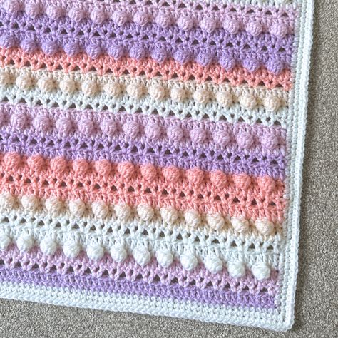 "Get ready to embark on a crochet adventure with the Oribus Blanket – Free Crochet Pattern, a project that’s as fun to make as it is to snuggle under! This free crochet pattern is perfect for beginners, combining the best of three beloved stitches: the versatile V-stitch, the classic double crochet (dc), and the playful bobble stitch. Each row brings something new, with the V-stitches adding a delicate, lacy texture, the double crochets providing a solid, cozy foundation, and the bobbles po Crochet Bobble Blanket Pattern, Bobble Stitch Blanket, Crochet Bobble Blanket, Bobble Blanket, Blanket Pattern Crochet, Baby Afghan Patterns, Crochet Terminology, Bobble Crochet, Crochet Bobble