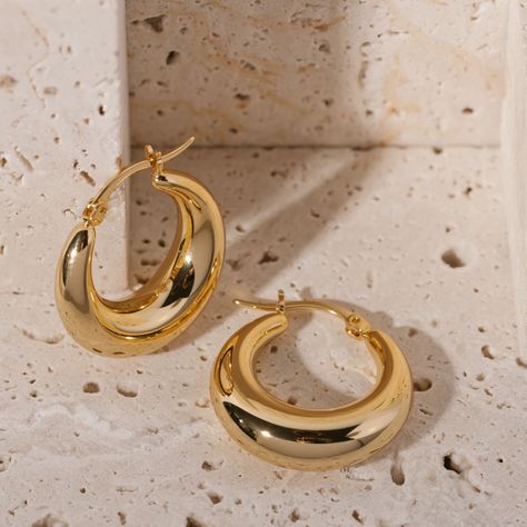 The Capri Hoop earring is bold, smooth, and light. It has a crescent shape inspired by the coastal Capri, and it's elegance reflects that of the famous resort town. Sold as a pair.   Details 18K triple layered gold over brass; reinforced with a fourth layer PVD coating The Perfect Hoop earrings feature high-quality materials that are durable, stylish, and comfortable to wear. Here are a few ways to keep your hoops looking pristine!  DAILY CARE Keep your hoops in their best condition by removing them before exercising or showering. It is also best to apply perfumes, creams, and hair care products before putting on your hoop earrings. We pride ourselves on the quality of our products. However, regular exposure to any of the above products can cause your earrings to tarnish. It is also possib Gold Hoops Earrings Medium, Womens Gold Earrings, Aesthetic Earrings Gold, Gold Hoop Earrings Aesthetic, Capsule Wardrobe Jewelry, Coastal Earrings, Hoop Earrings Aesthetic, خواتم خطوبة, Chunky Gold Hoop Earrings