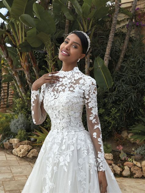 Ethereal romance meets classic opulence in style 1231. Delicate floral lace adorns her strappy, corset, sweetheart neck bodice and voluminous, shimmering tulle skirt. A magnificent, lace embellished long sleeve jacket with sheer high neck and button closure adds a regal touch to this transitional beauty. Matching jacket JA03 (sold separately). High Neck Lace Wedding Dress, Long Sleeve Ball Gown Wedding Dress, Demetrios Bridal, A Line Ball Gown, High Neck Long Sleeve Top, 2024 Wedding Dresses, Long Sleeve Wedding Gowns, High Neck Wedding Dress, Neck Wedding Dress