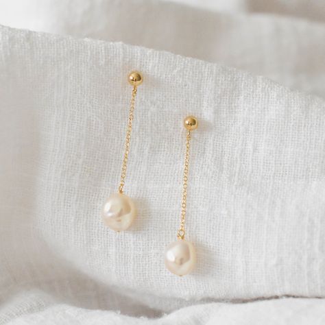 These earrings are handmade to order and are customizable. For custom requests, please message me for details.  These earrings feature a simple gold chain drop and a single freshwater pearl. Pearl shape is slightly oval and off-round. Made of 14K gold filled materials and genuine freshwater pearls, these earrings are tarnish-resistant, water-resistant, and hypoallergenic. Earring length is customizable.  Model is wearing the 1.5 in long version.  --------------------♥ PROMOS ♥------------------- Simple Pearl Jewelry Set, Gold Pearl Bridal Earrings, Droopy Pearl Earrings, Small Gold Dangle Earrings, Simple Pearl Drop Earrings, Pearl Droplet Earrings, Asymmetrical Pearl Earrings, Gold And Pearl Drop Earrings, Yellow Gold Pearl Earrings