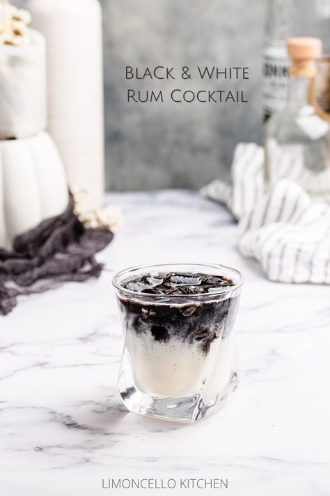 creamy white cocktail in an old fashioned glass with a layer of black on top White And Black Cocktail, Black And White Drinks Cocktails, Cow Themed Cocktails, Black And White Appetizers, Black Rum Cocktails, Oreo Cocktail, Black Drinks Cocktails, Black And White Party Food, Black And White Drinks