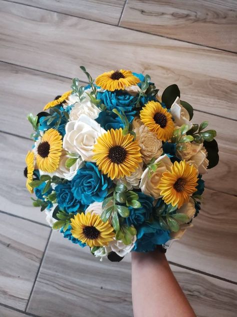 Sola wood flower wedding bouquet with turquoise flowers as well as yellow sunflowers. Greenery is a mixture of artificial and preserved. Pictured is the large 12 inch bridal. Handle is wrapped in blue ribbon and lace. Can also add matching bridesmaid bouquets, corsages and boutonnieres per request. Made to order! Each flower is hand made and painted so a slight variation in placement may occur from one bouquet to the next.Can also be made in different colors. Please message me for custom quotes. Yellow And Teal Wedding Theme, Yellow And Turquoise Wedding, Wedding Gatsby, Sunflower Bridal Bouquet, Purple Flower Bouquet, Wedding August, Rustic Sunflower Wedding, Bee Wedding, Sunflower Wedding Bouquet