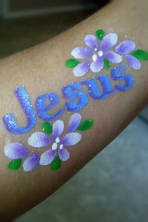 "Jesus" & Flowers on arm- Smiley Faces by Jo Easter Face Paint, Diy Lip Plumper, Spring Eye Makeup, Fairy Face Paint, Face Painting For Boys, Diy Tattoo Permanent, Christmas Face Painting, Arm Painting, Girl Face Tattoo