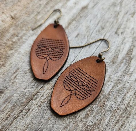 Handmade genuine leather earrings with a vintage western look. Engraved, lightly oiled then burnished to a bright shine. Finished with antique gold findings. Dimensions: 2 x 0.9 in (5.1 x 2.3 cm) Laser Gifts, Boho Leather Jewelry, Laser Engraved Earrings, Handmade Leather Jewelry, Canvas Bag Design, Country Jewelry, Leather Earring, Cowgirl Jewelry, Western Earrings