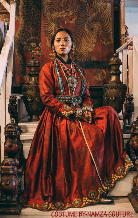 Wearing Ladakhi Culture means, you wearing a Ladakhi dress and Ladakhi jewellery. A "Sulma" in this picture is the red gown. The big coral earrings "Akor". The turquoise and coral necklace with a big amulet "Gau", which is considered the main piece of jewellery in Ladakhi wedding. Then below that is an ornament worn by the women of Sham valley, its called "Rhuptsey". The top part is tied to the neck and the bottom part around the waist so that the lotus-shaped jewellery is right in the centre. Traditional Ladakhi Dress, Dress That Ties Around Neck, Cultural Outfits Traditional Dresses, Ladakhi Dress, Cultural Clothing, Global Dress, Culture Clothing, Asian History, Period Outfit