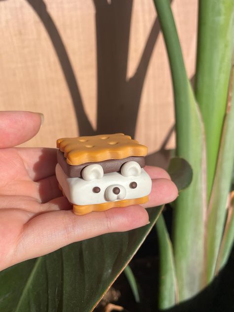 A lil smores bear desk buddy - inspired by my favorite camping activity! Hope this lil guy brightens your desk as he does mine :) Handmade with polymer clay and glazed with resin for a glossy shine and sturdiness. Option for no glaze is available (personally, I love the look of unglazed clay). Unglazed desk buddies will be a little more vulnerable than their glazed counterparts. Dimensions (approximate):  1.5 in width, 1.5 in length, 1 in height 3.7 cm width, 3.7 cm length, 2.5 cm height Foam Clay Ornaments, Clay Polaroid Stand, Cute Simple Clay Ideas, Mini Clay Ideas Easy Simple, Polymer Clay Desk Buddies, Clay Cute Things, Clay Smores, Clay Date Inspo Pics, Clay Desk Buddies