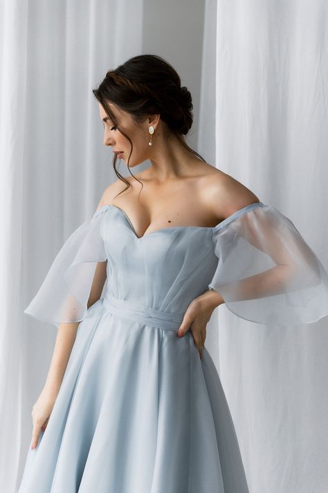 Blue wedding dress for your important day! Charming, fairy light blue wedding gown that you will fall in love with. The A-line bridal gown made from organza is perfect. Sweetheart corset bridal dress with light, flowy short sleeves and accent on the waist- belt looks elegant and fairy. Classic lacing on the back adds romantic notes to the look. On the waist, there is a belt that emphasizes your figure. Corset with off-the-shoulder short flowy sleeves makes this dress so unique. Light Blue Flowy Dress Short, Blue Spring Wedding Corset Dress, Luxury Blue Flowy Dress, Light Blue Flowy A-line Dress, Luxury Light Blue Organza Gown, Blue Bridal Dress, Wedding Gown With Sleeves, Blue Wedding Gowns, A Line Bridal Gowns