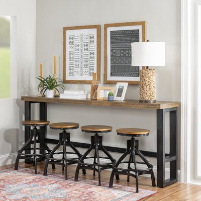 This counter height bar table and swivel stools are industrial vintage, rustic and the hand distressing enhances the overall aesthetic. The combination of materials, like the poplar veneer wood top, black hand distressed metal finish, and the extra thick metal tube base has an industrial appeal that will look great in any setting. Color: Brown | Williston Forge Wellman 4-Person Pub Table & Stool Set 36.0 H in black / whiteWood / Metal in Brown | Wayfair Rustic Pub Table, Sofa Bar Table, Sofa Bar, Accent Table Decor, Counter Height Dining Table, Counter Height Dining Sets, Wood Sofa, Table Stool, Pub Table