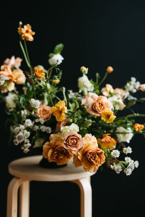 This fall-inspired floral arrangement by Alyssa Lytle of Color Theory Design Co. balances bold autumnal colors with delicate natural textures to create a stunning centerpiece. “A little orange, red, and yellow go a long way. I like to soften the fall tones with creamier colors such as peach, terra-cotta, and ivory,” says the Portland-based designer. “It’s amazing how some wild grasses, seeding branches, or herbs from your garden can transform the feel of your arrangement." Autumn Fern, Fall Flower Arrangements, Fall Floral Arrangements, Portland Wedding Photographer, Fall Flower, Flower Farmer, Spray Roses, Flower Farm, Fall Collection