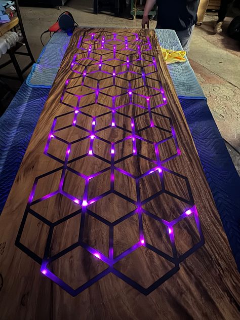 MONKEY POD WALNUT HONEYCOMB DESK LENGTH: 85" (INCHES) WIDTH: 30.5"(INCHES) THICKNESS: 2"(INCHES) Honeycomb pattern cut with our CNC machine, then a smoke black resin poured through out all of the slab of wood. Then, LED lights carefully installed to the bottom of the table to ensure a BEAUTIFUL illumination through out the whole table!  - We can create any size/ any wood! Message me with any questions you might have, we can also cut any logo in a piece of wood and add LED lights to brighten up your work space! Table With Resin, Led Desk, Metal And Wood Table, Gaming Coffee Table, Wood And Epoxy Projects, Game Cafe, Craft Cart, Wood Shop Projects, Honeycomb Pattern