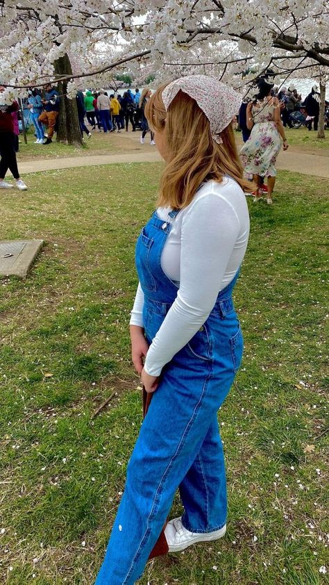 A girl under a Cherry Blossom tree, looking away from the camera. She is wearing a white hair scarf with pink and green flowers, a white long sleeve shirt, a pair of long blue demin overalls and white tennis shoes. She is holding a brown corduroy tote bag. Girl Overalls Outfit, Hair Bandanas, Head Kerchief, Boho Scarf, Soft Girl Outfits, Hair Clips For Women, Girls Overalls, Girls Fall Outfits, Boho Scarfs