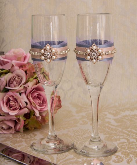 "This listing is for the set of 2 champagne glasses.  Toasting flutes for the bride and groom decorated with lilac tulle, blush and dusty blue ribbons, rhinestone and pearl trim and rose gold jewels. Your guests will be so impressed with the attention to detail. It can be a perfect gift for wedding ceremony! Height of the glasses 8 1.4\". Custom color: I can decorate champagne toasting flutes in any color you wish, please send me a convo with the colors you are looking for.  Please check our col Champagne Glasses Decorated, Champagne Flutes Wedding, Gold Champagne Flutes, Champagne Toasting Flutes, Wedding Toasting Glasses, Bride And Groom Glasses, Quince Decorations, Toasting Flutes Wedding, Wedding Champagne Glasses