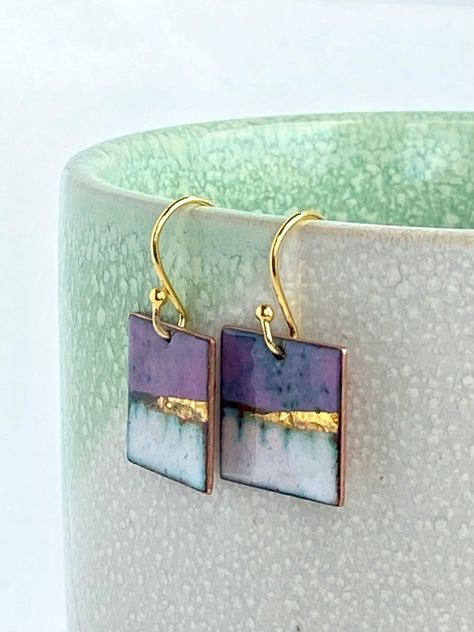 Square enamel copper earrings inspired by landscapes available in lilac purple. These handmade enamel earrings are absolutely gorgeous.  They are dainty enough to wear for any occasion, and that tiny bit of gold gives it a warm opulent glow.   You are going to love wearing them, or why not gift them to that special friend or loved one.  To create the impression of a landscape layers of vitreous enamel were used to build up the depth and variation in colour and finished off with a sliver of 24ct Enamel Techniques, Copper Enameling, Enameling Jewelry, Polymer Clay Painting, Vitreous Enamel, Enameled Copper, Clay Jewelry Diy, Statement Drop Earrings, Earrings Inspiration