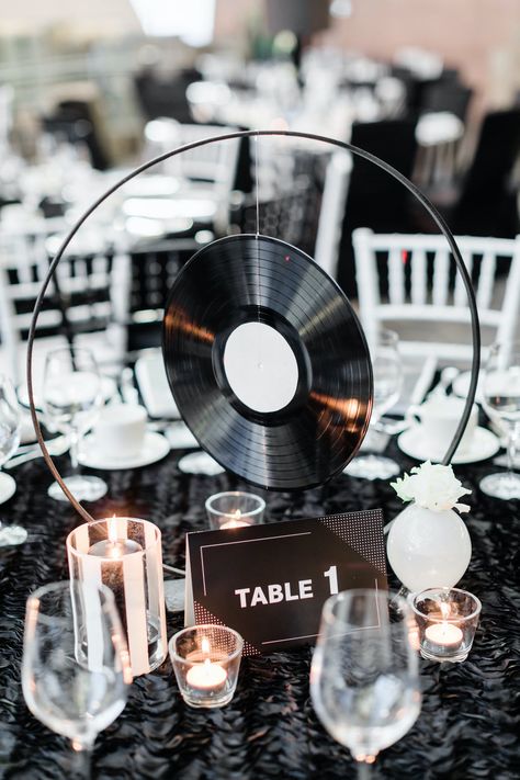 This holiday party took their guests back in time by using vinyl records as centerpieces. See how this celebration brought guests through the different parts of the Beatles' career from black and white to eccentric and full of color. You need to see all the creative details that went into this event. Vinyl Record Wedding Centerpieces, Wedding For Music Lovers, Soul Train Centerpieces, Vinyl Centerpieces Wedding, Record Themed Party, Vinyl Record Themed Party, Music Themed Wedding Centerpieces, Music Themed Table Decorations, Rock Party Centerpieces