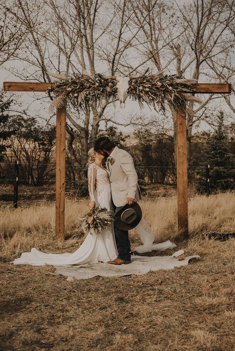 Outdoor Cowboy Wedding, Western Unity Ceremony, Longhorn Wedding Arch, Country Wedding Isles, Boho Western Wedding Arch, Small Country Wedding Ideas Outdoor, Deer Antler Wedding Arch, Western Arches Wedding Ideas, Country Field Wedding