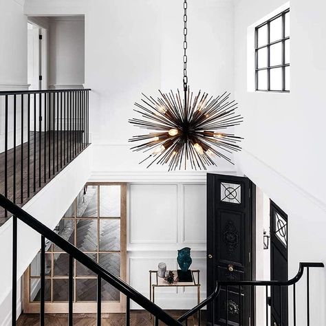 Light radiates from this chandelier. The chandelier is a striking departure from the ordinary. The lights are surrounded by black metal rods helping to set this light as the star of the room. With 12 dimmable lights it is as versatile as it is bold. Statement Chandelier Entryway, Stairwell Chandelier, Entry Chandelier, Front Foyer, Starburst Chandelier, Entryway Chandelier, Sphere Chandelier, Rectangular Chandelier, Foyer Chandelier