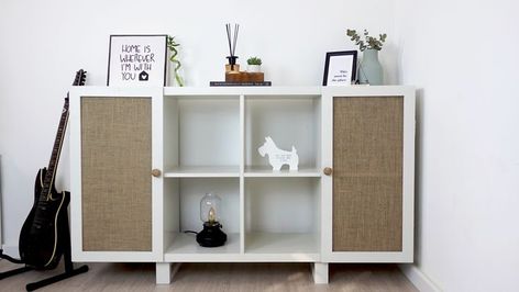 a white shelving unit with burlap doors and cute decorations Double Kallax Hack, Diy Ikea Cube Storage Makeover, Kallax Door Hack Diy, Kallax Diy Door, Diy Doors For Cube Storage, Diy Kallax Doors, Kallax Transformation, Kallax Doors Diy, Ikea Kallax Doors Diy