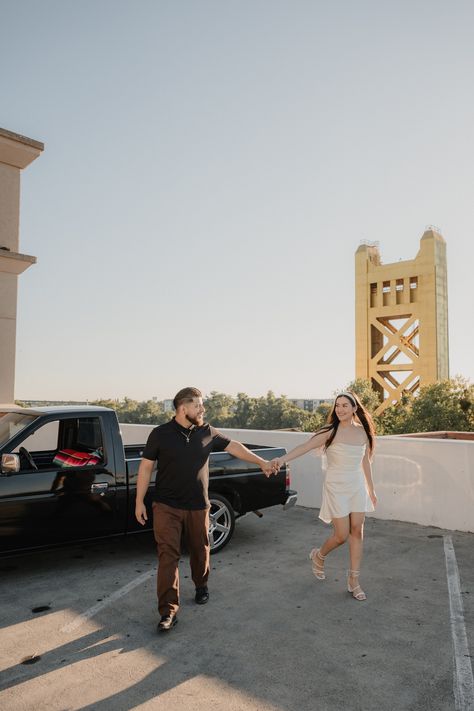 Couple hold hands on the rooftop with stunning view of the Tower Bridge for Old Sacramento of beautiful engagement session captured by wedding and portrait photographer based in Sacramento CA Downtown Sacramento Photoshoot, Sacramento Engagement Photos, Couple Hold Hands, Sacramento Photoshoot, Old Sacramento, Baby 2024, Downtown Sacramento, Hold Hands, Maternity Shoot