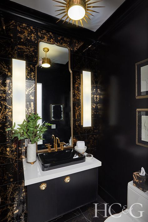 Eryn Oruncak channeled “romantic glamour” for her powder room, which features glossy black walls, black wall tile with gold splatter from The Tile Shop, and a floating black Kohler vanity. Thomas O’Brien’s Albertine sconces for Circa Lighting and Oruncak’s own artwork add another layer of sophistication. Powder Room by Elan Design, Photograph by Anastassios Mentis Black And Gold Powder Room, Gold Powder Room, All Black Bathroom, Black Powder Room, Downstairs Wc, Moody Bathroom, Powder Room Ideas, Black And Gold Bathroom, Powder Room Wallpaper