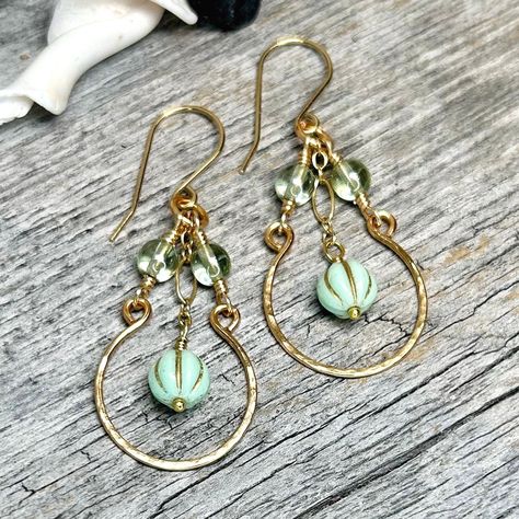 These Vintage style earrings feature a mint green melon bead falling from gold-filled chain with fire polished soft green accent beads and a cold-forged gold hoop all falling from handmade jeweler's brass ear wires.  * Earrings Measure: 2 3/8" long x 7/8" wide * Czech Glass Beads * Jeweler's Brass Handmade Ear Wires & Hoops. * US Quarter Shown for Size Reference. * Item is finished and ready to ship! * Ships within 1-3 business days via USPS Ground Advantage with Tracking. * Items ship from Alaska, so please allow a little extra time for arrival! For more about these earrings and more, follow me on instagram and facebook: @907northdesigns Green And Gold Earrings, Green Melon, Earrings Diy Handmade, Vintage Style Earrings, Fancy Earrings, Focal Beads, Earrings Inspiration, Homemade Jewelry, Handmade Wire Jewelry