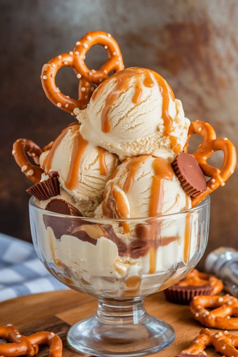 Salted caramel ice cream topped with pretzels and peanut butter cups in a glass bowl. Sundae Ice Cream Ideas, Sundaes Ideas Ice Cream, Ice Cream Ideas For Business, Food Photography Ice Cream, Ice Cream Sundae Aesthetic, Pretzel Ice Cream, Ice Cream Ideas, Ice Cream Sundae Recipe, Unique Ice Cream Flavors