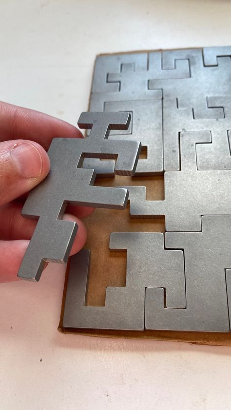 "STILL POSSIBLE TO RECEIVE BY DECEMBER 24 (But trust the dates Etsy shows you!) These puzzles are laser cut from 1/8\" thick 304 stainless steel and measure 5\"x5\" (3mm x 127mm x 127mm). The result weighs almost 1 pound (400g) which is satisfyingly heavy. Without decoration, both sides of each piece look identical which makes this is more difficult to solve than 20 pieces might suggest. Perfect for a coffee table or desk toy. We can laser etch a photo, logo, or text on some pieces or all of the Metalwork Projects, Laser Cut Furniture, Desk Toy, Metal Signage, Metal Puzzles, Laser Cut Steel, Diy Xmas Gifts, Paper Craft Videos, Steel Detail