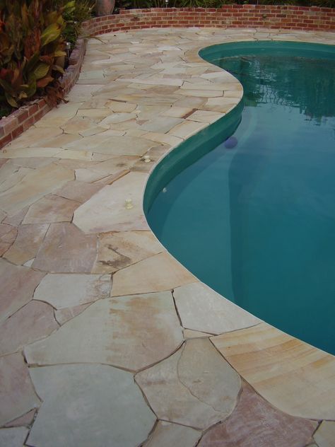 Curved Sandstone pool coping to blend with crazy paving. A continuous natural look #sandstone #pool #natural #poolcoping #kidneyshapepool Crazy Paving Around Pool, Crazy Pavers Pool, Pool Crazy Paving, Curved Pool Coping, Sandstone Crazy Paving, Crazy Paving Pool, Sandstone Courtyard, Pool Deck Stone, Flagstone Pool Coping